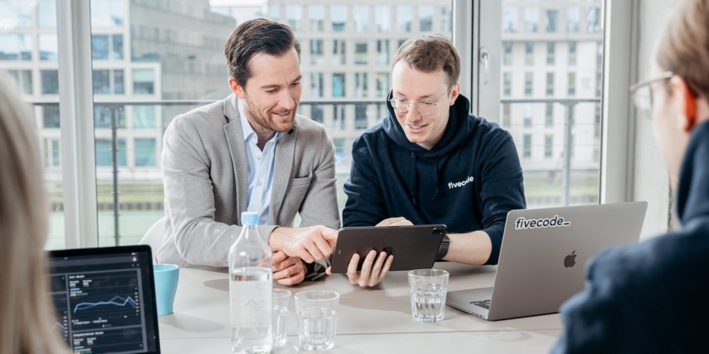 fivecode Mitarbeiter zeigt Kunden seine neue WordPress Webseite in Münster